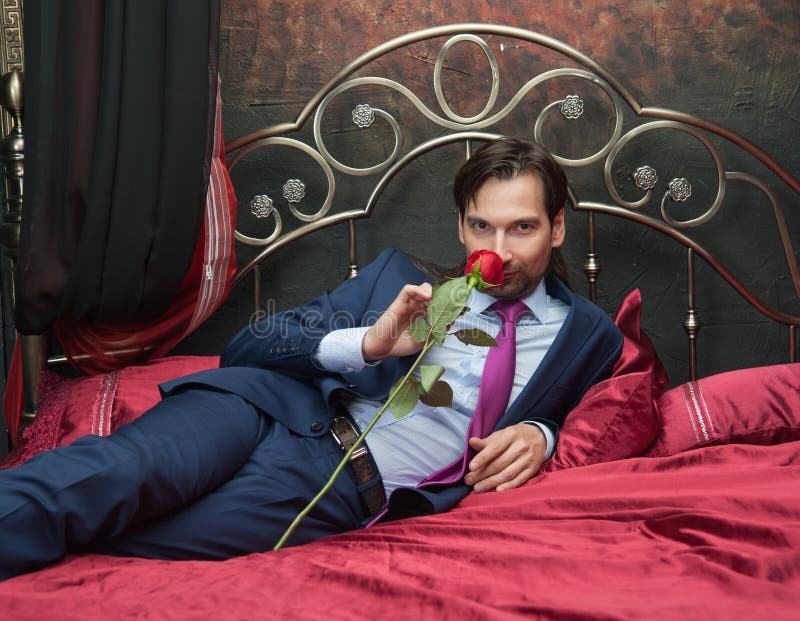 Create meme: A man is lying with a rose, a man lies with a rose in his mouth, the man with the roses