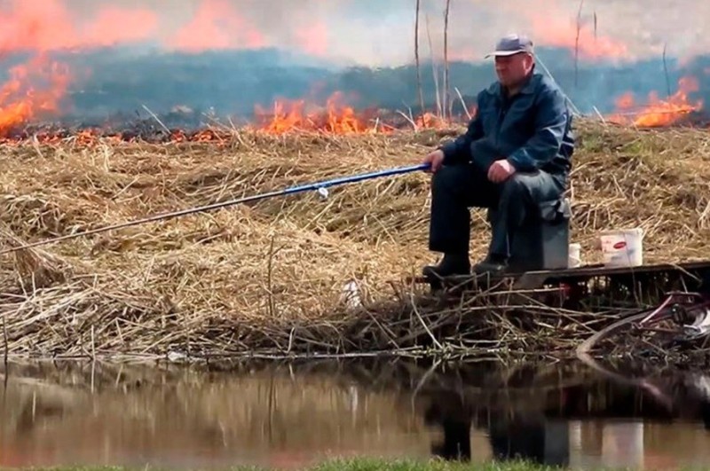 Create meme: a fisherman on the background of a fire, fires, fishing 