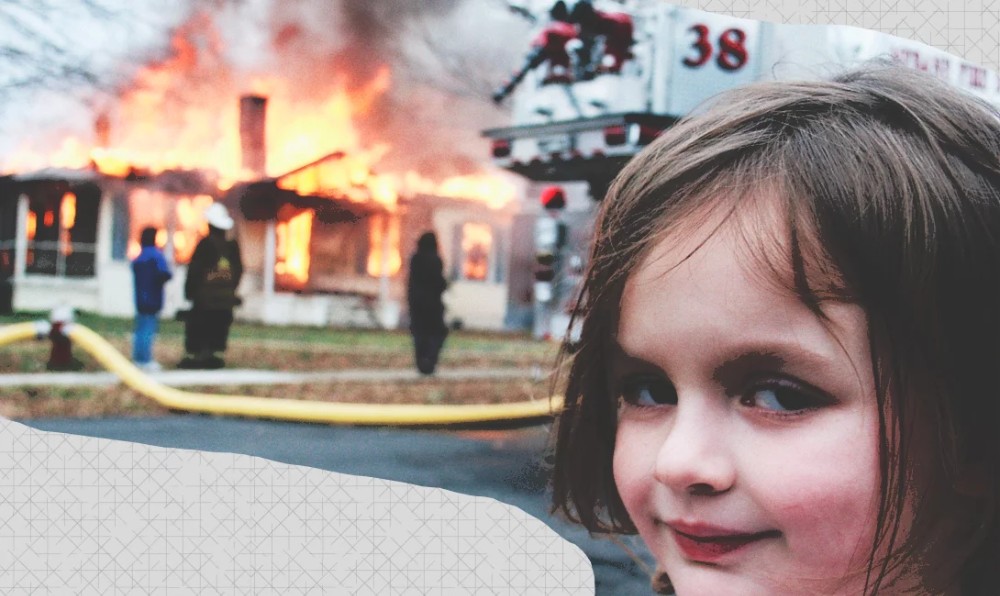 Мем где девочка на фоне горящего дома