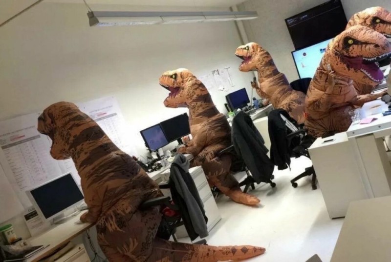 Создать мем: люди в костюмах динозавров в офисе, офисные приколы, динозавры в офисе
