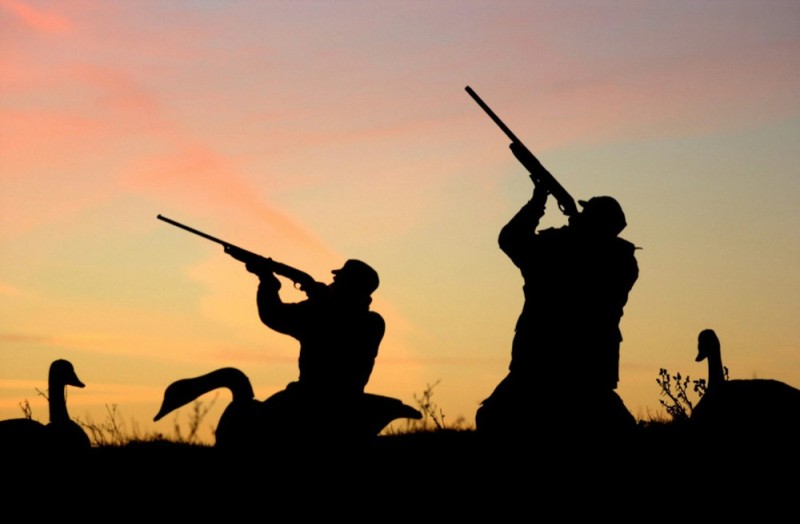 Create meme: hunter with a gun, the hunter on the background of the sunset, The hunter at sunset