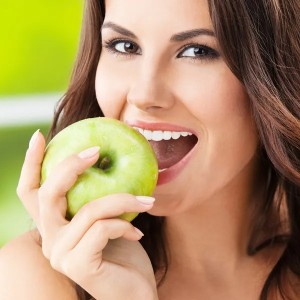 Создать мем: женщина с яблоком, кусает яблоко, красивая улыбка зубы