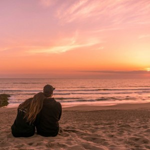 Create meme: couple at sunset, two at sunset by the sea, beach sunset