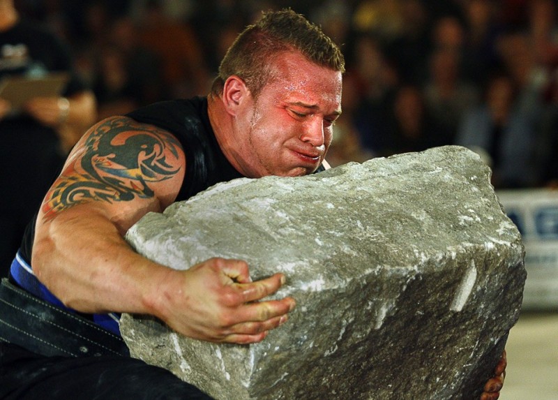 Create meme: strongman Atlas stones, Arnold Classic Strongman, A man picks up a stone