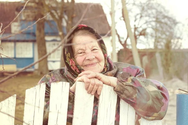 Create meme: the grandmother in the village, grandma , grandmother at the fence in the village