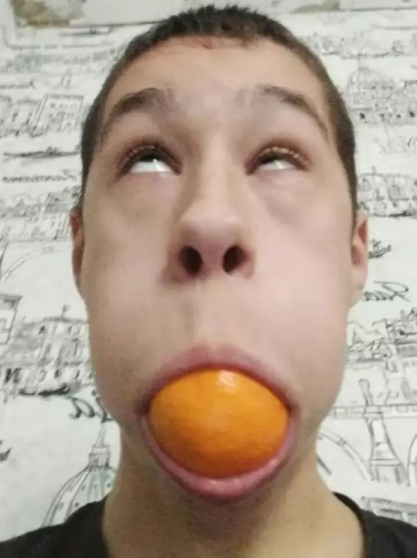 Create meme: eggs in the mouth, boy , A man with an orange in his mouth